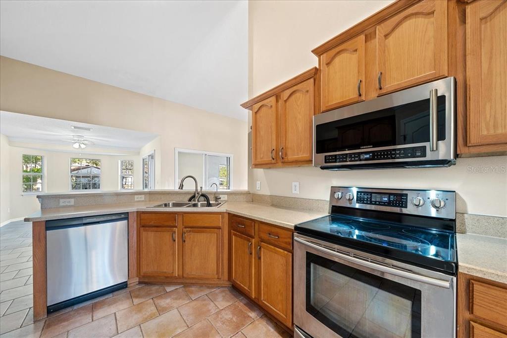 10308 Southwest 83rd Terrace Ocala, FL 34481 - Photo 52 of 75 a kitchen with stainless steel appliances a stove microwave and sink