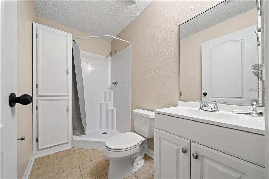 10308 Southwest 83rd Terrace Ocala, FL 34481 - Photo 74 of 75 a bathroom with a toilet a sink a mirror and a shower