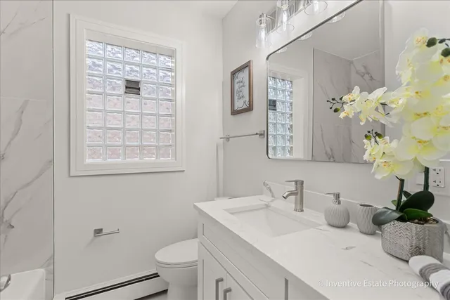 a bathroom with a sink a toilet and a mirror