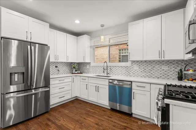 a kitchen with stainless steel appliances white cabinets and a refrigerator