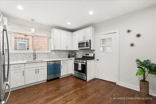 a kitchen with granite countertop white cabinets and black stainless steel appliances