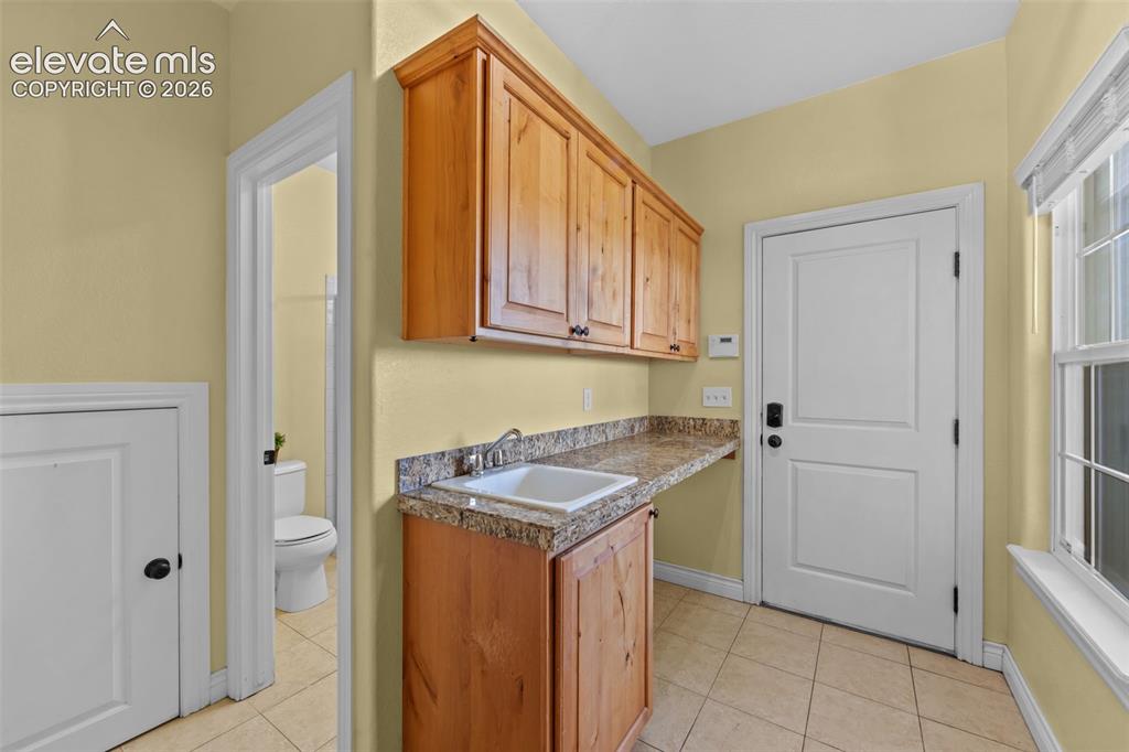 16540 Mesquite Road Peyton, CO 80831 - Photo 18 of 50 a utility room with cabinets washer and dryer