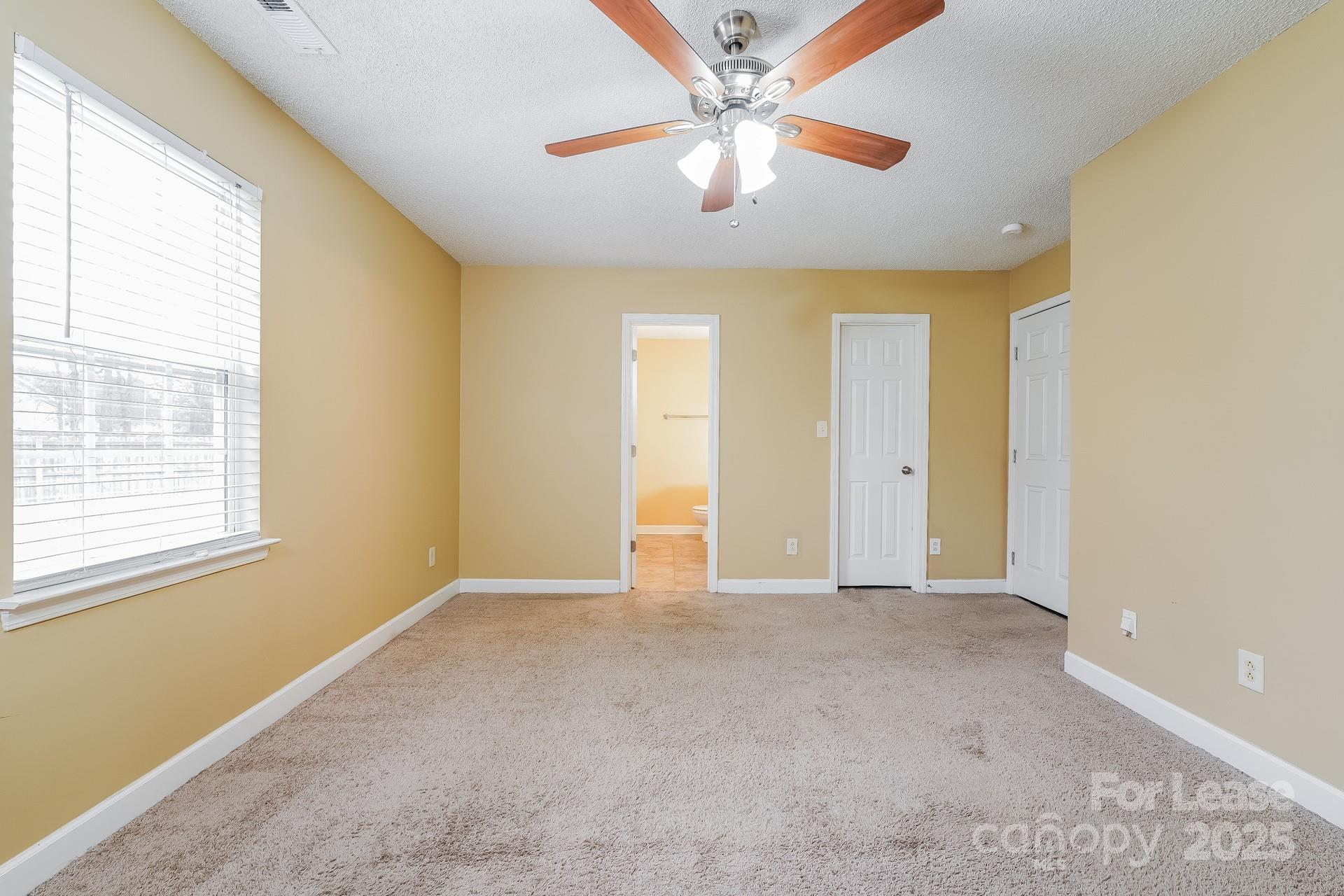 4110 Runaway Circle Monroe, NC 28110 - Photo 8 of 16 an empty room with chandelier fan and windows