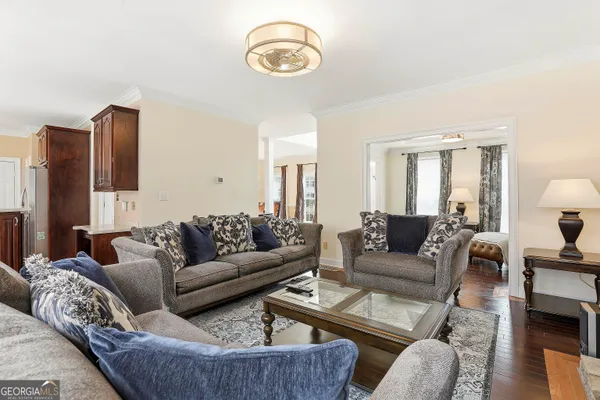 a living room with furniture kitchen view and a window