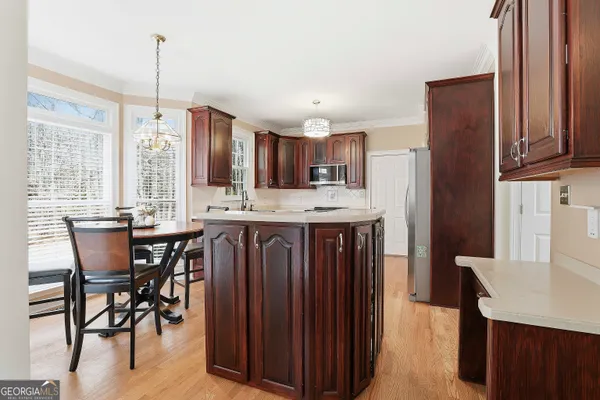 a kitchen with a table chairs refrigerator and cabinets
