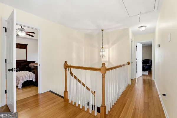 a view of a hallway with wooden floor and staircase