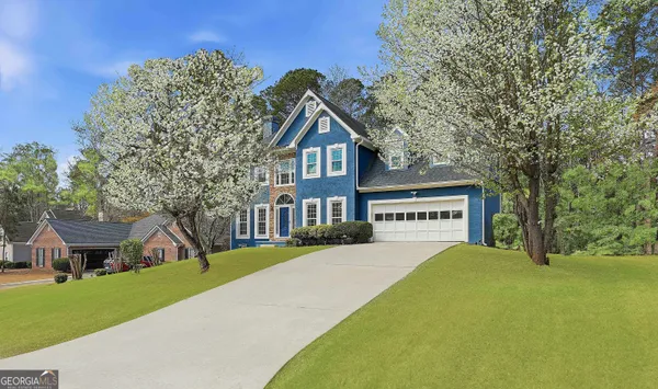 a front view of a house with a yard and trees