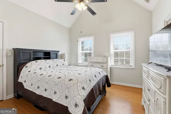 a bedroom with a large bed and a flat tv screen on dresser