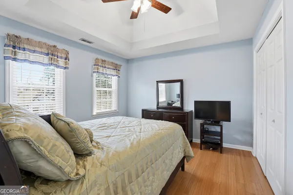 a view of a hallway with wooden floor and closet