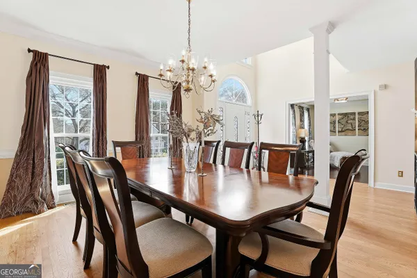 a view of a dining room and livingroom with furniture wooden floor and a chandelier
