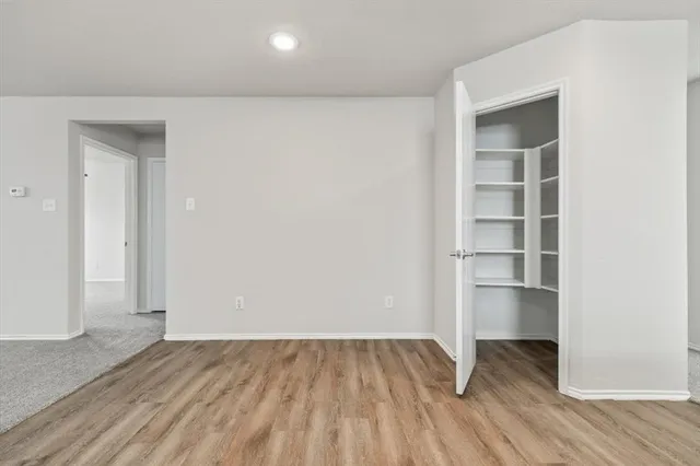 an empty room with a hardwood and closet
