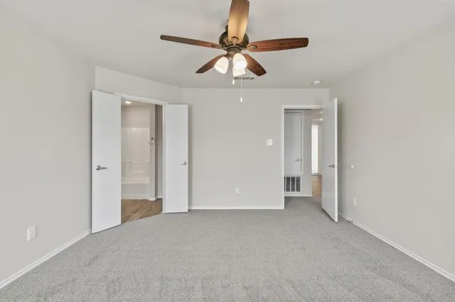a view of empty room with ceiling fan