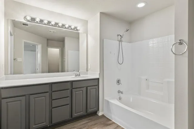 a bathroom with a tub a sink and mirror