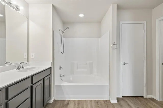a bathroom with a granite countertop sink a mirror bathtub and shower