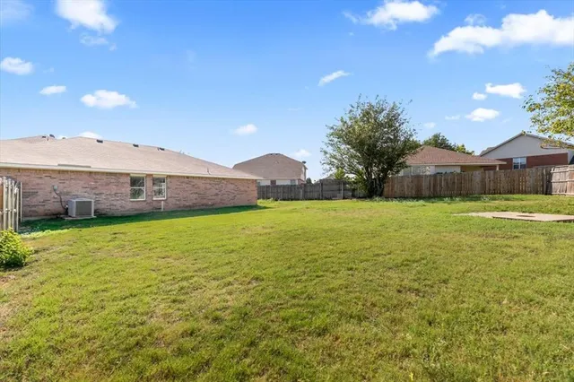 a view of a large pool with a big yard and a large tree in the background