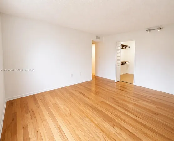 a view of empty room with wooden floor