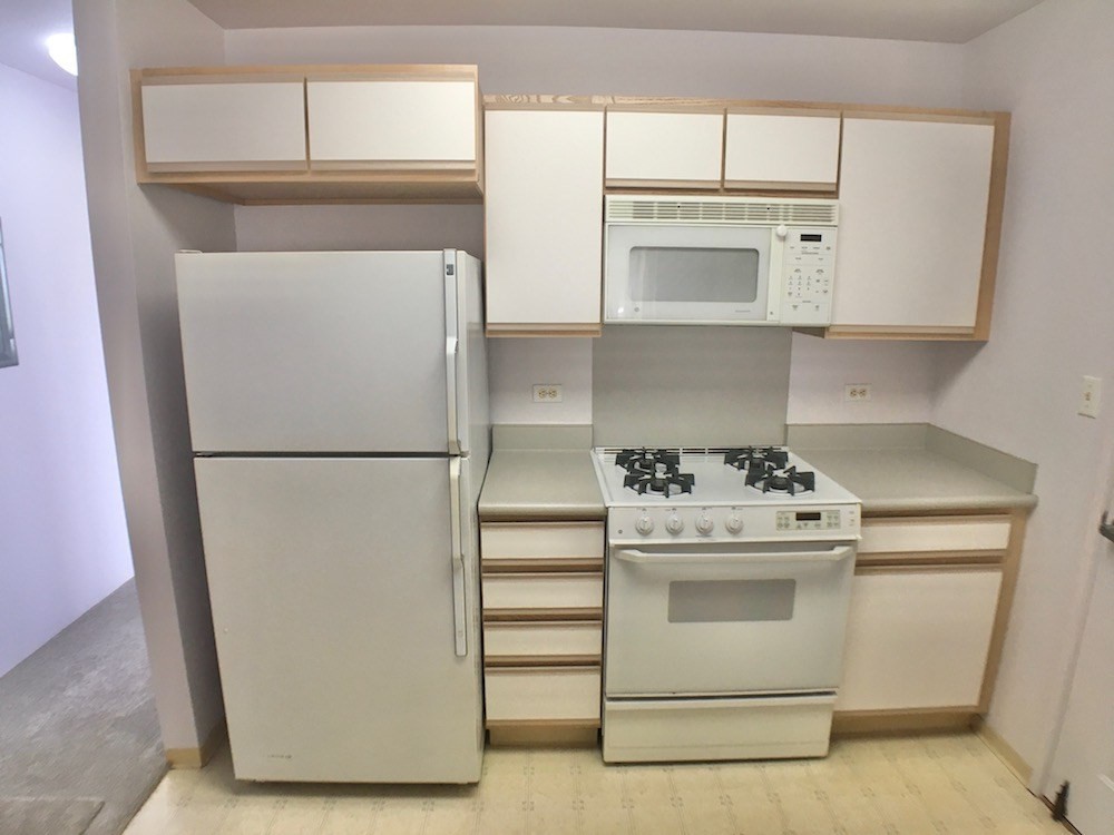 5005 Moi Road Hanapepe, HI 96716 - Photo 4 of 17 a kitchen with white cabinets and white appliances