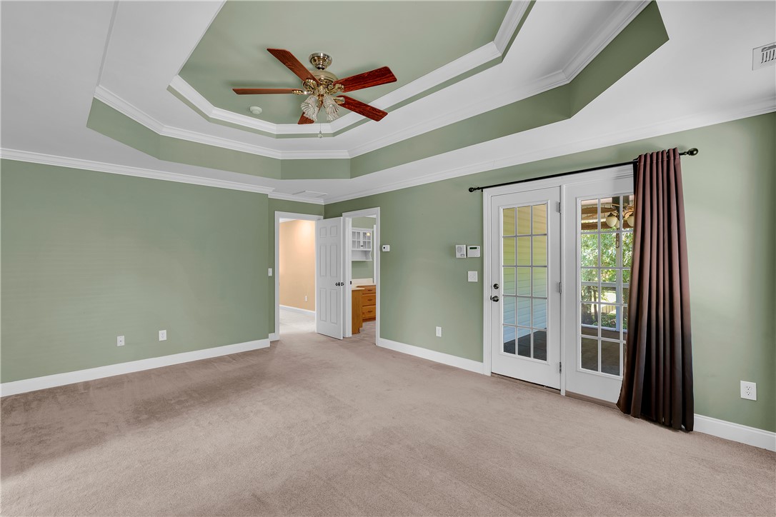 406 Hopewell Ridge Anderson, SC 29621 - Photo 19 of 46 This primary bedroom features elegant tray ceilings, direct outdoor access, and plush carpet flooring.