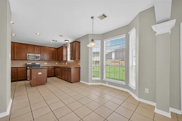 a kitchen with stainless steel appliances a refrigerator a sink a stove top oven and cabinets