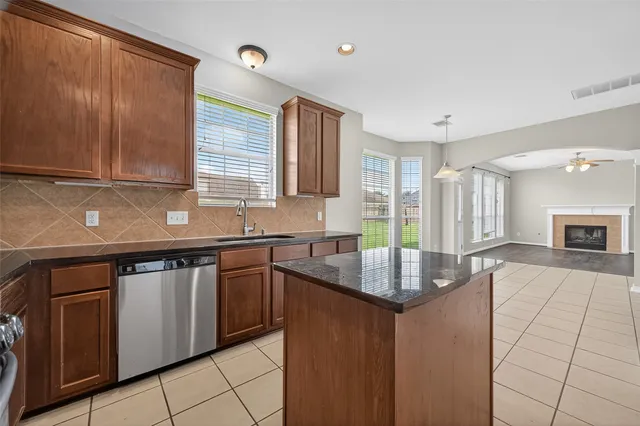 a kitchen with granite countertop a sink stove and cabinets