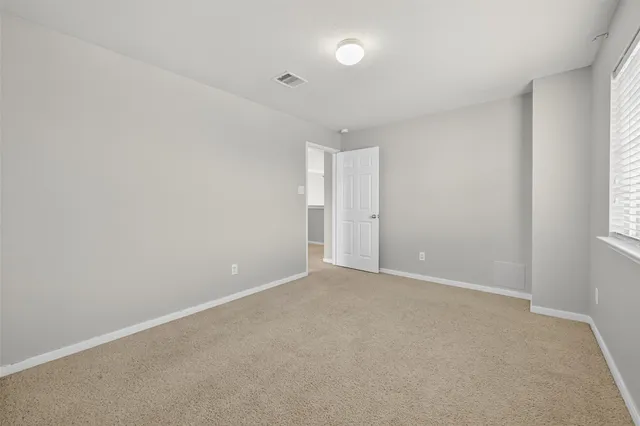 an empty room with windows and closet