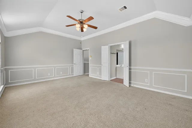 an empty room with closet and a ceiling fan
