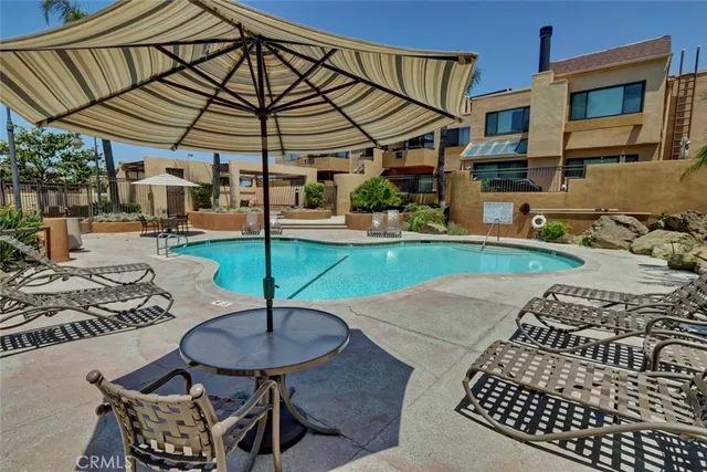 a patio with table and chairs and potted plants