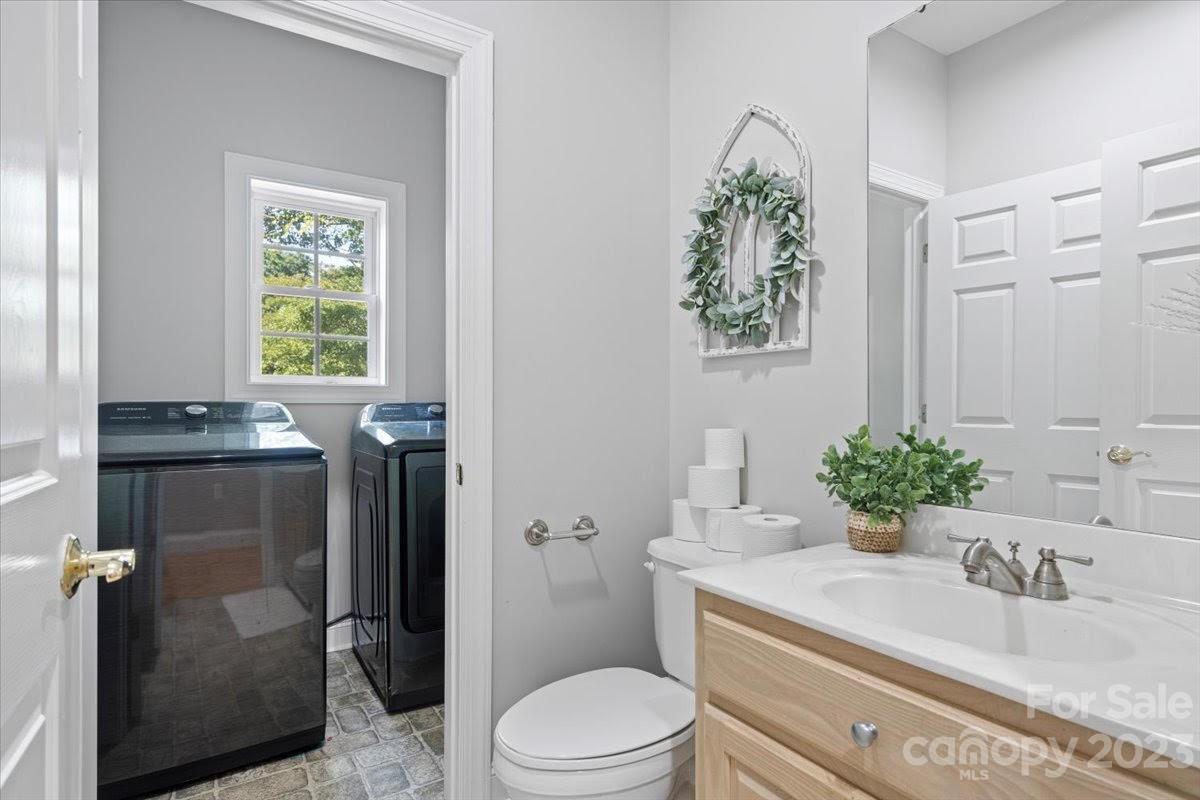 1531 Henry Smith Road Monroe, NC 28110 - Photo 13 of 31 a bathroom with a granite countertop sink a toilet and a mirror