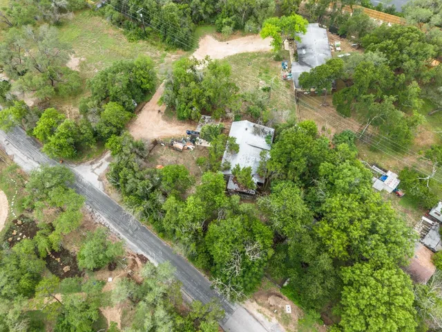 an aerial view of residential house with outdoor space and trees all around