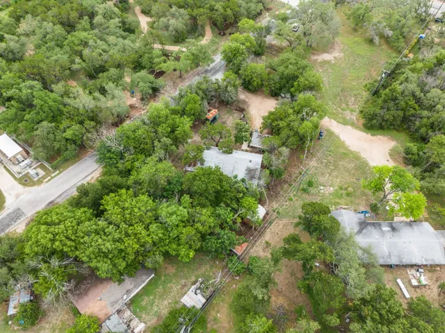an aerial view of residential houses with outdoor space and trees