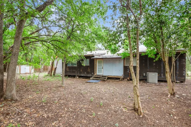a view of a house with backyard and a tree