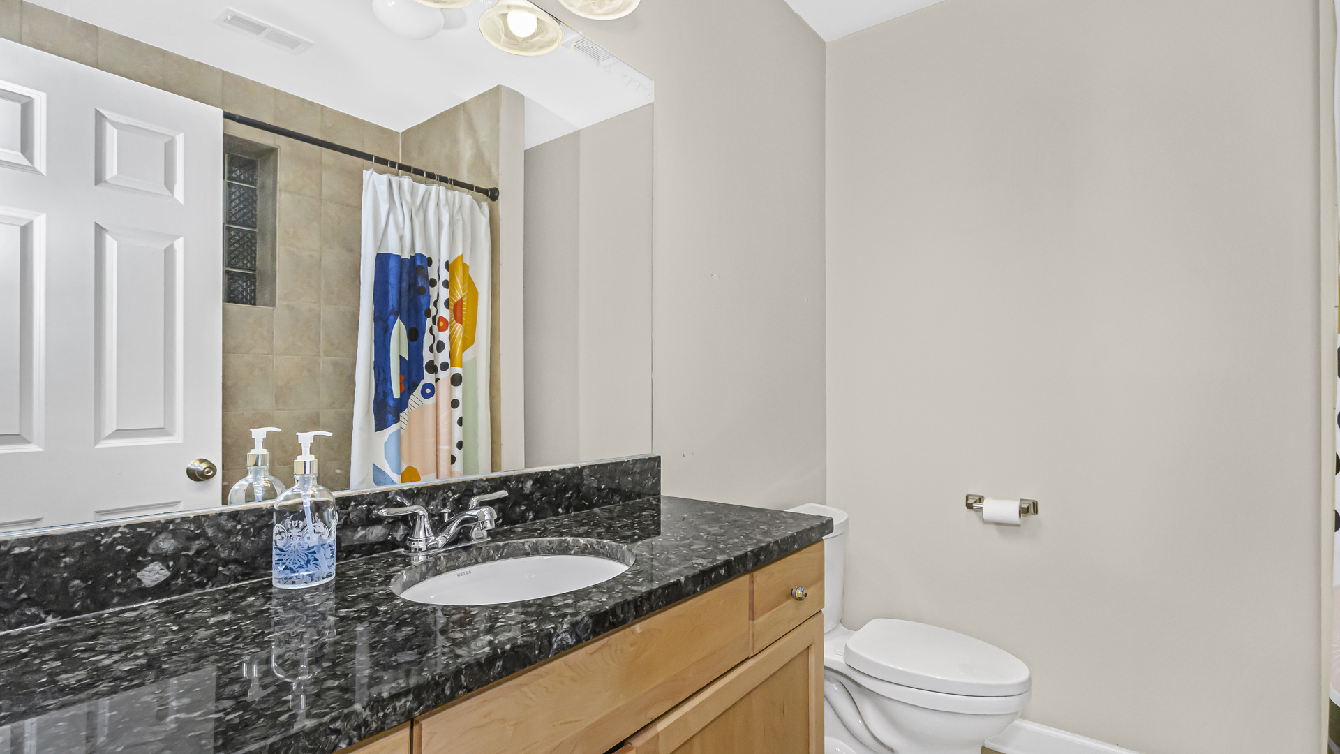 1430 West Chestnut Street, Unit 1 Chicago, IL 60642 - Photo 11 of 14 a bathroom with a granite countertop sink vanity mirror and toilet