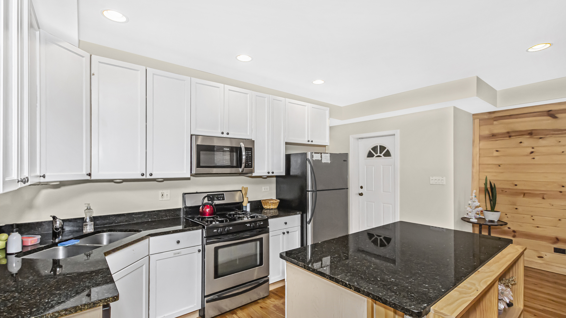 1430 West Chestnut Street, Unit 1 Chicago, IL 60642 - Photo 4 of 14 a kitchen with stainless steel appliances granite countertop a sink a stove and a refrigerator