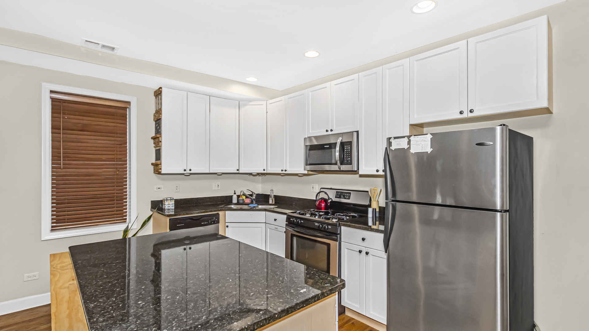 1430 West Chestnut Street, Unit 1 Chicago, IL 60642 - Photo 5 of 14 a kitchen with stainless steel appliances granite countertop a refrigerator sink stove microwave and cabinets