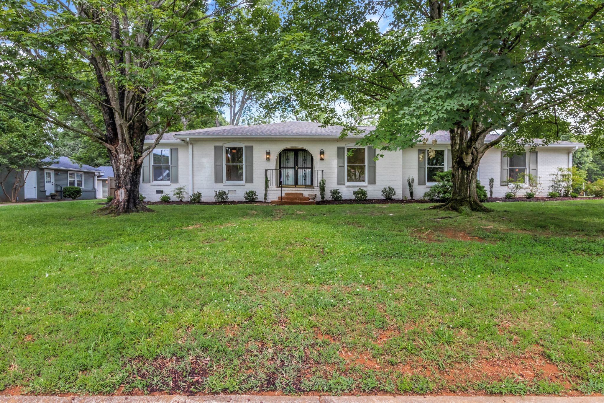 a front view of a house with a garden