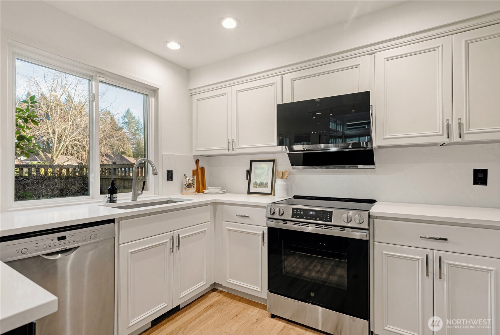 4016 243rd Place Southeast Issaquah, WA 98029 - Photo 10 of 35 a kitchen with white cabinets stainless steel appliances and a window