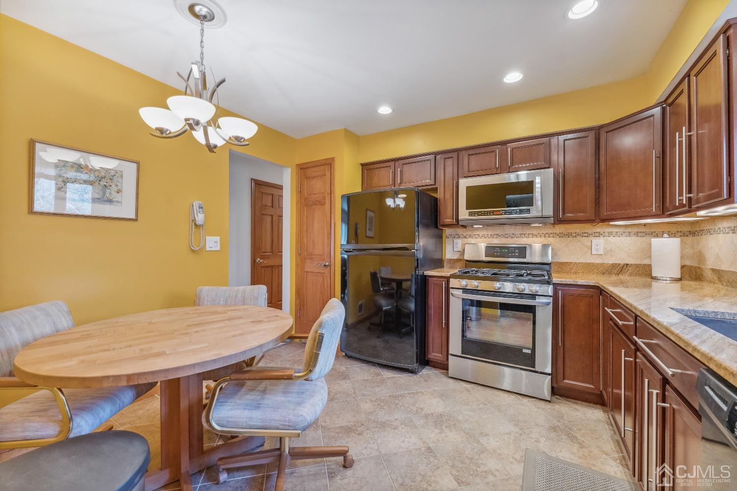 53 Bristol Road Piscataway, NJ 08854 - Photo 8 of 33 a kitchen with stainless steel appliances granite countertop a stove a refrigerator a kitchen island a dining table and chairs
