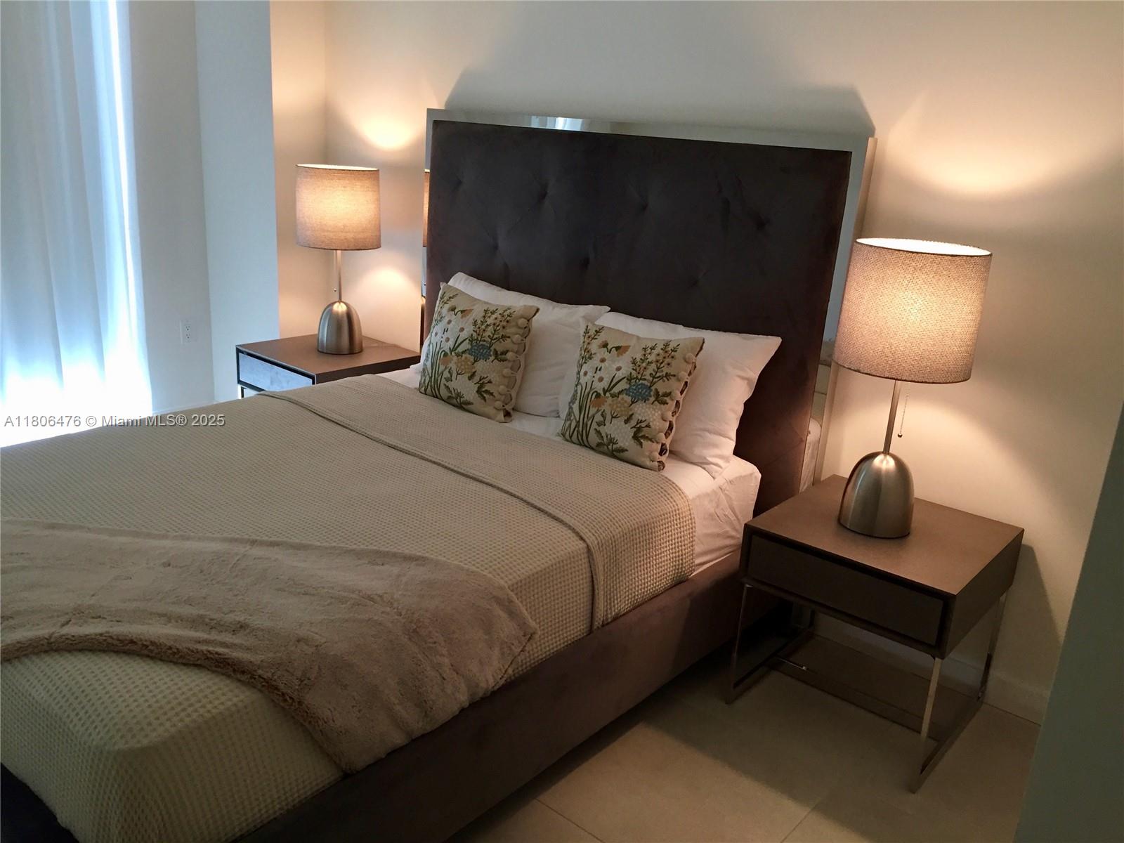 401 North Birch Road, Unit 505 Fort Lauderdale, FL 33304 - Photo 11 of 29 a large bed sitting in a bedroom next to a lamp