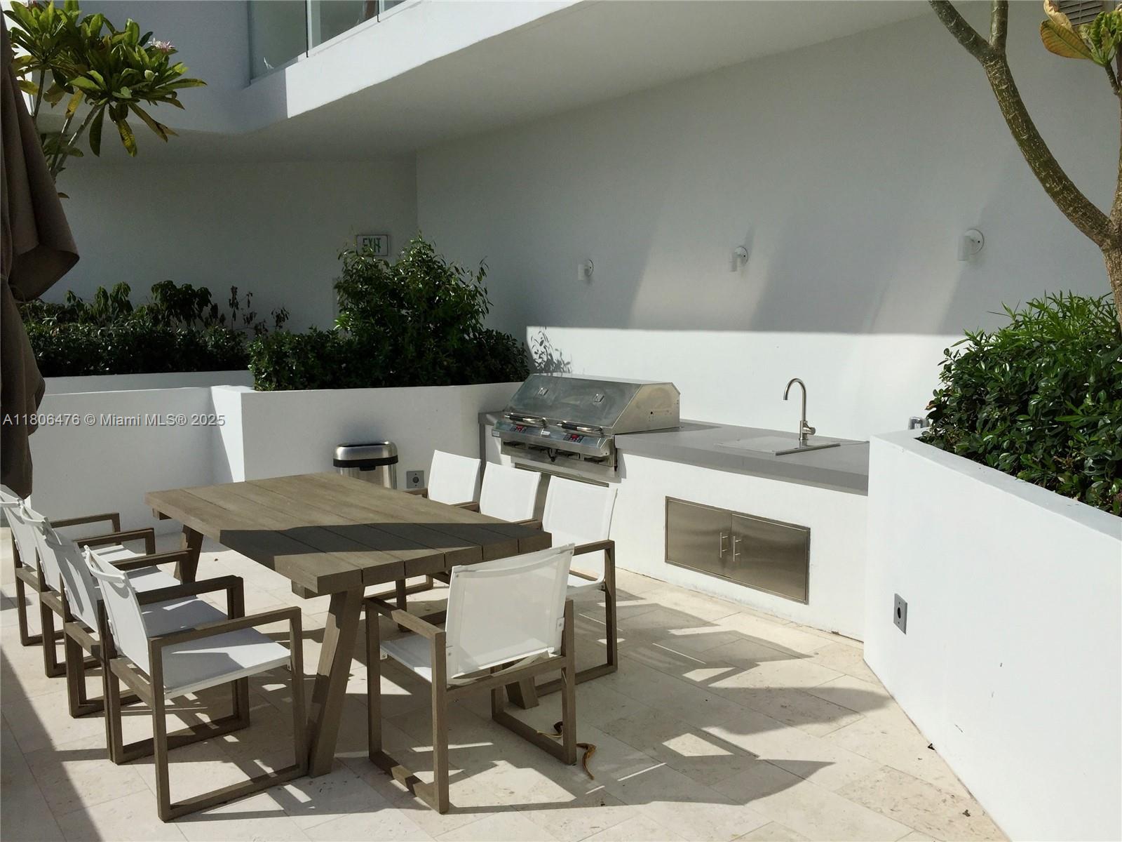 401 North Birch Road, Unit 505 Fort Lauderdale, FL 33304 - Photo 23 of 29 a patio with table and chairs with potted plants
