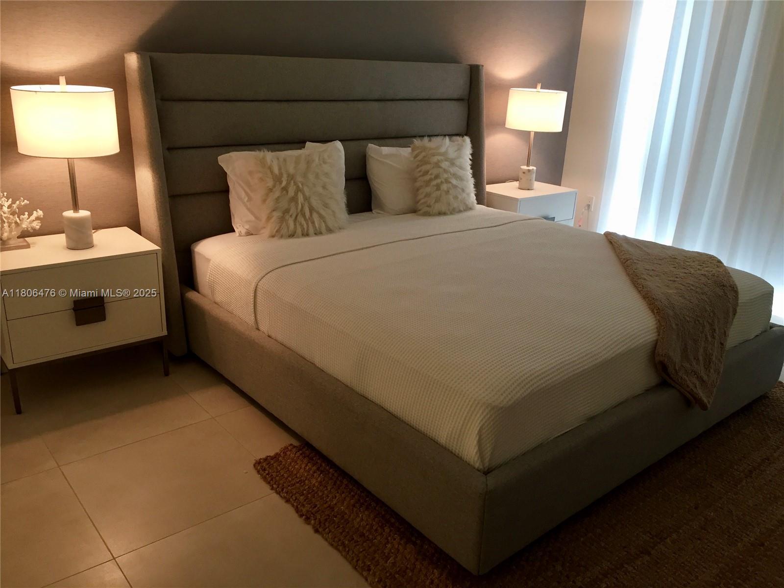 401 North Birch Road, Unit 505 Fort Lauderdale, FL 33304 - Photo 6 of 29 a bed sitting in a bedroom next to a lamp