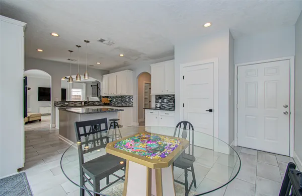 a living room with granite countertop kitchen island stainless steel appliances furniture a dining table and kitchen view