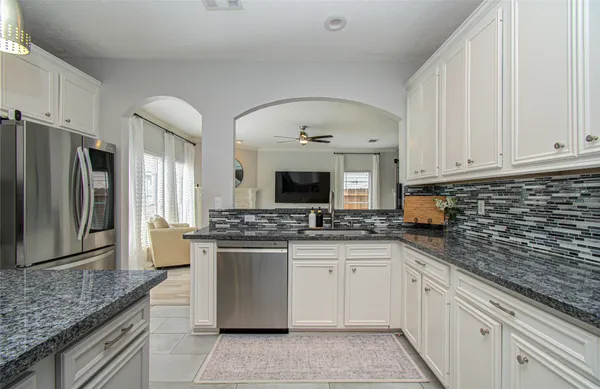 a kitchen with stainless steel appliances granite countertop a stove top oven a sink a counter space and cabinets