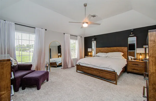 a spacious bedroom with a bed and a couch