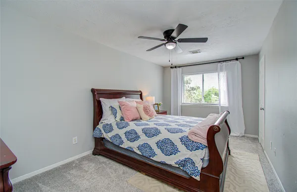 a bedroom with a bed window and a chandelier