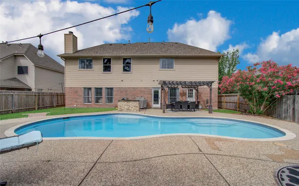 a view of house with swimming pool outdoor seating