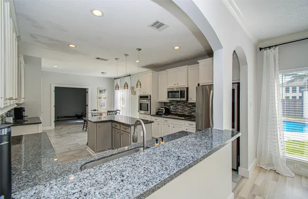 a large kitchen with stainless steel appliances kitchen island granite countertop a large counter top stainless steel appliances and cabinets