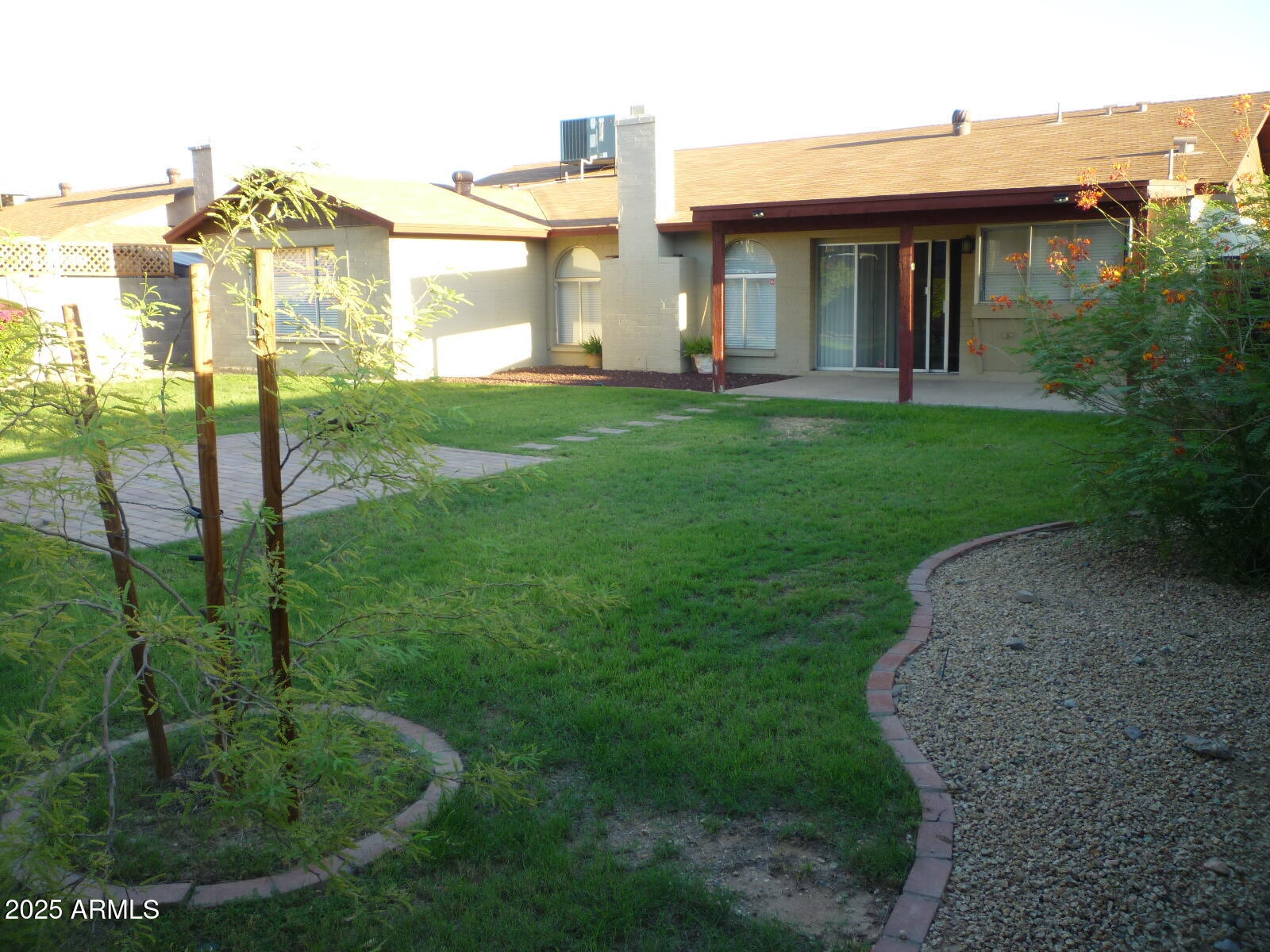 4216 West Willow Avenue Phoenix, AZ 85029 - Photo 13 of 14 a view of a white house next to a yard with big trees