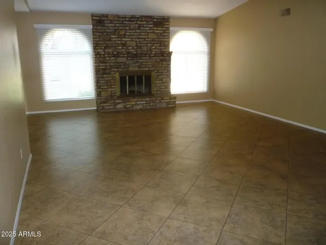 an empty room with wooden floor and a fireplace
