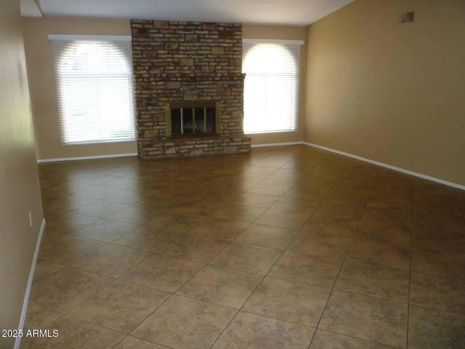 4216 West Willow Avenue Phoenix, AZ 85029 - Photo 2 of 14 an empty room with wooden floor and a fireplace