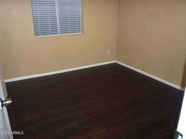 a view of a small space with wooden floor and a window